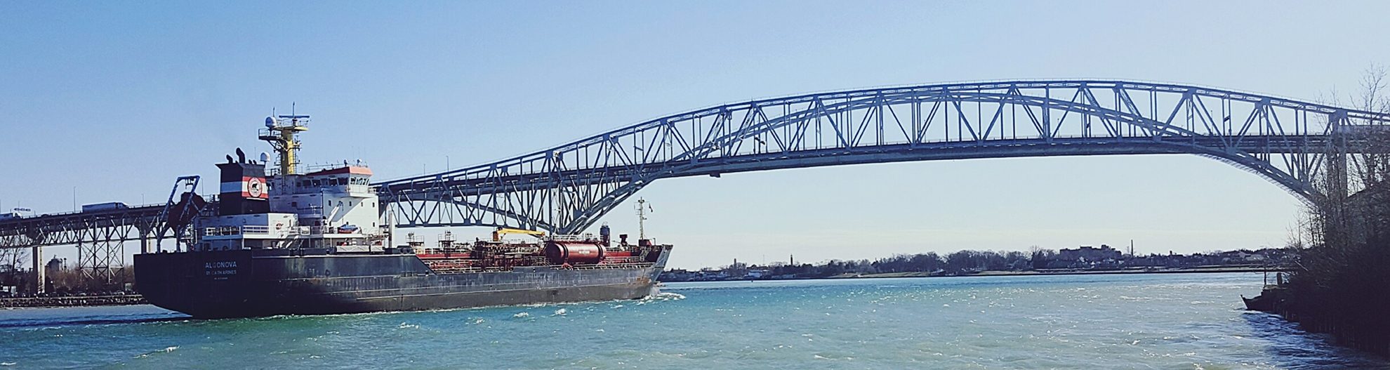 Ship on lake moving towards bridge